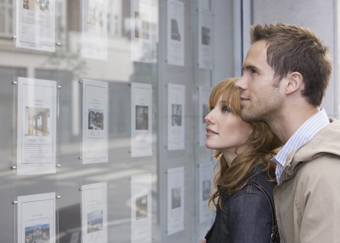 First time buyers viewing estate agent window